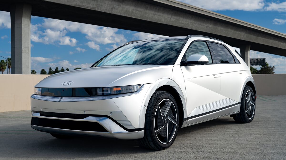 A front 3/4 view of the Hyundai Ioniq 5 parked on a cement parking structure on a sunny day.