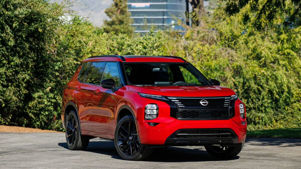 2026 Nissan Rogue in red parked outside.