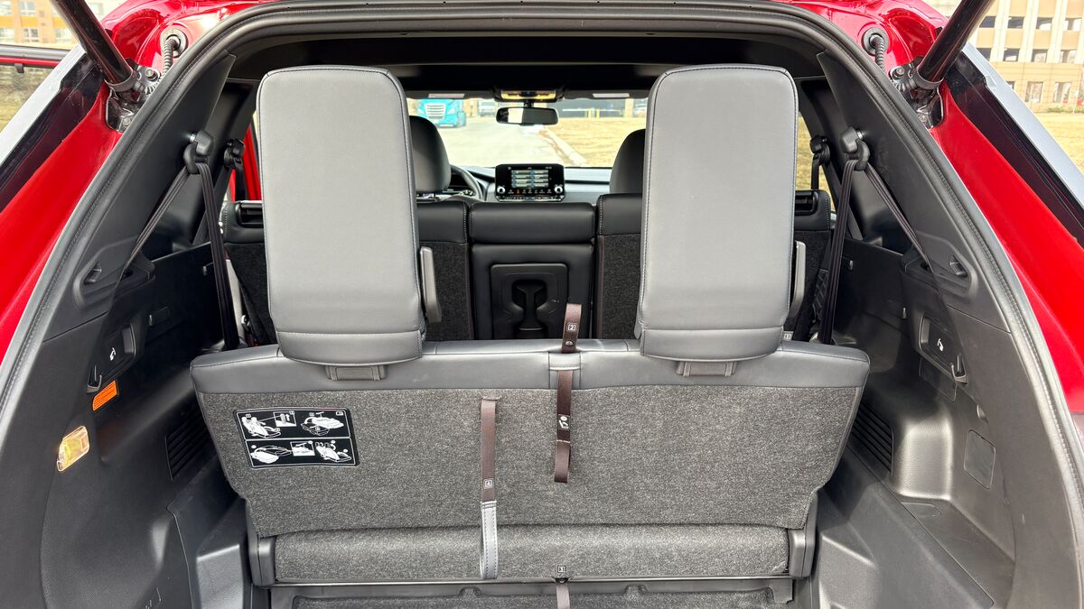 2026 Nissan Rogue PHEV in red with its trunk open.