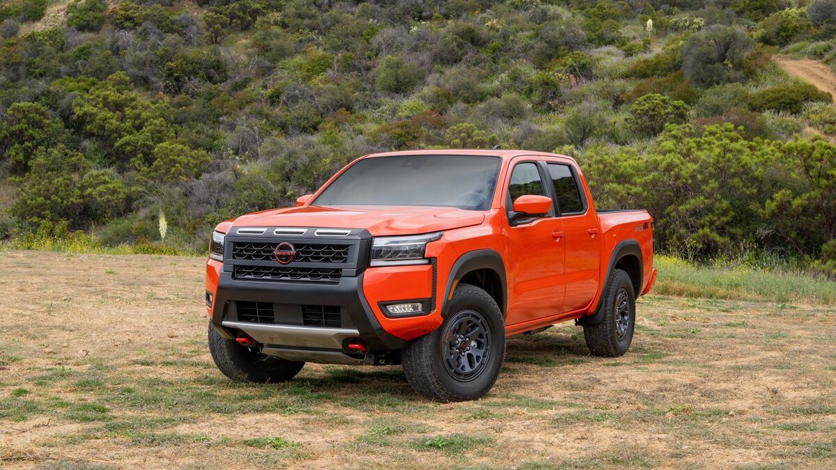 2026 Nissan Frontier in red parked on grass.