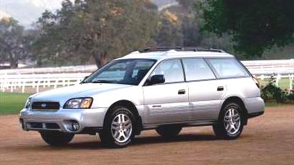 2004 Subaru Outback parked by a barn.