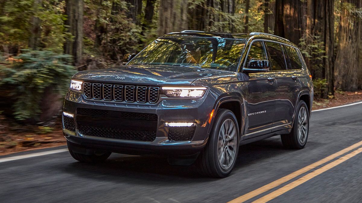 2025 Jeep Grand Cherokee L Summit Reserve driving through a forest.