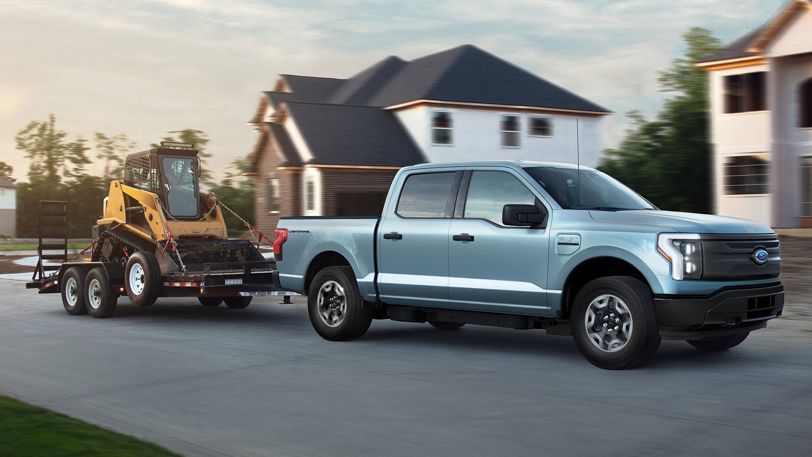 2022 Ford F-150 Lighning in silver towing heavy equipment