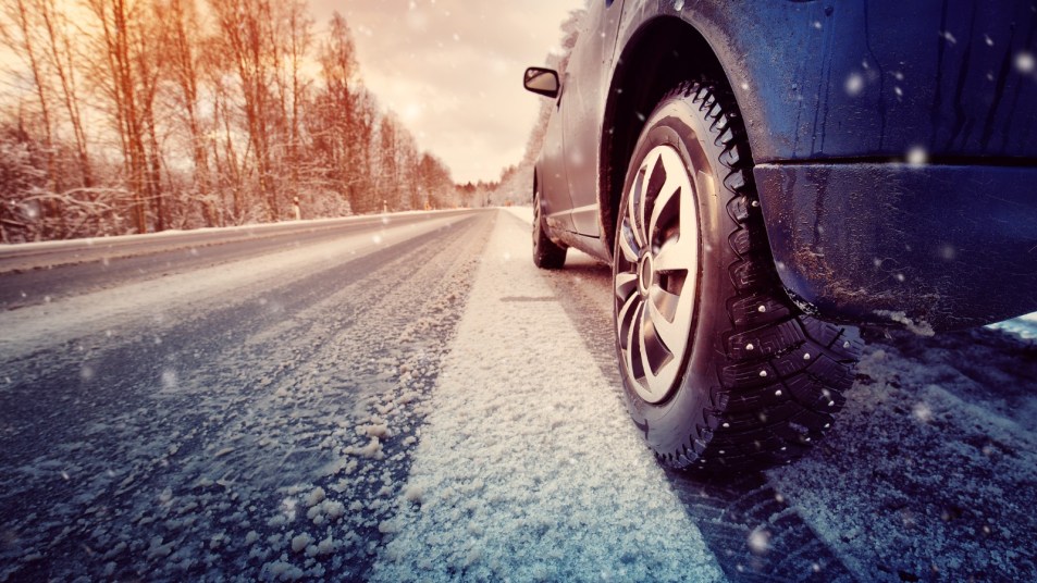 Car driving with snow tires on wintery road