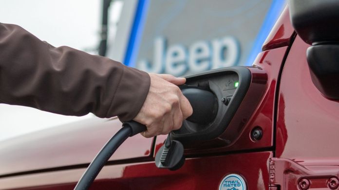 A man charging a Jeep Wrangler