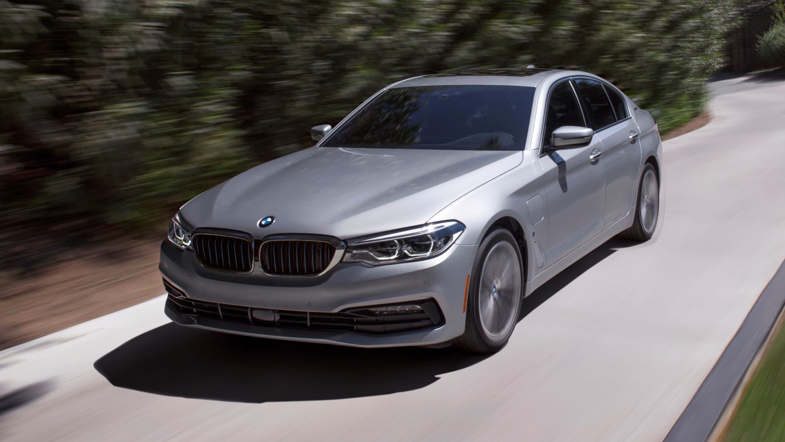 2019 BMW 5 Series driving in silver