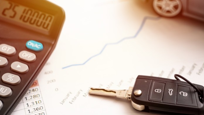 A calculator, budget and car key fob.