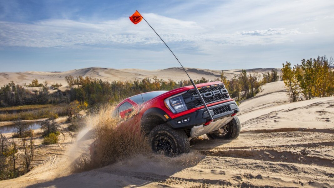 The 2023 Ford F-150 Raptor R churning sand as it tops a dune in our off-road tests