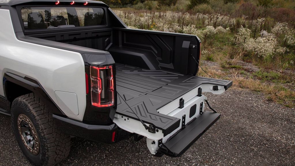 2023 GMC Hummer EV Pickup in white truck bed tailgate down with step ladder extended