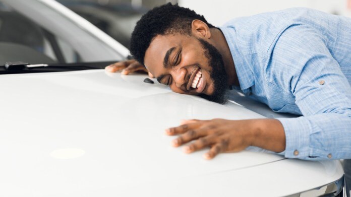 Person hugging car hood