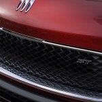 Close up view of grille and badge of the 2024 Buick Encore GX ST in Cinnabar Metallic. 