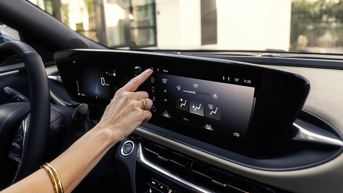 Driver interacting with the new Ultrawide Infotainment Display in the 2024 Buick Envista Avenir. Preproduction model shown. Actual production model may vary. Available in summer 2023.