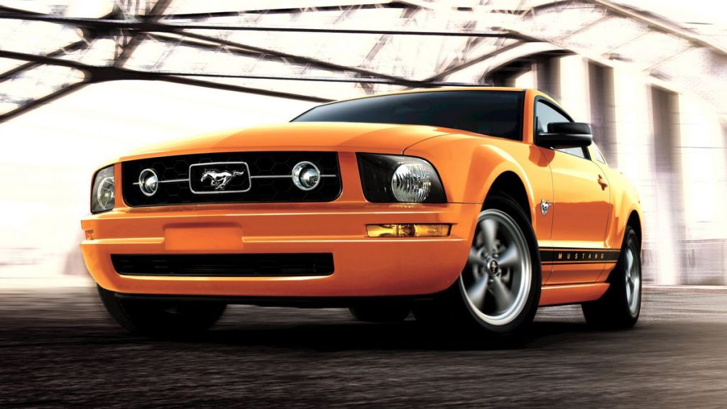 2009 Ford Mustang in Grabber Orange Clearcoat under a bridge.