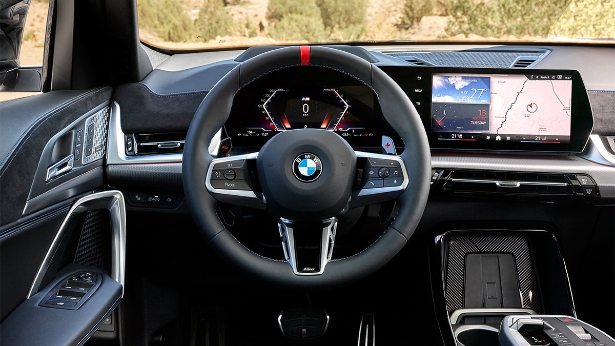 The X2 M35i has an M leather steering wheel with gearshift paddles and a red center marker, plus an Alcantara-trimmed instrument panel. 