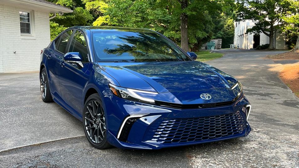 2025 Toyota Camry in blue parked outside of a house.