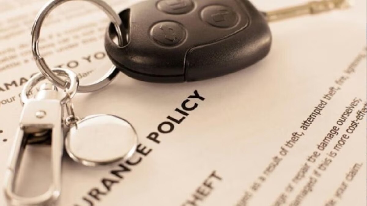 A car key on top of an insurance policy document.