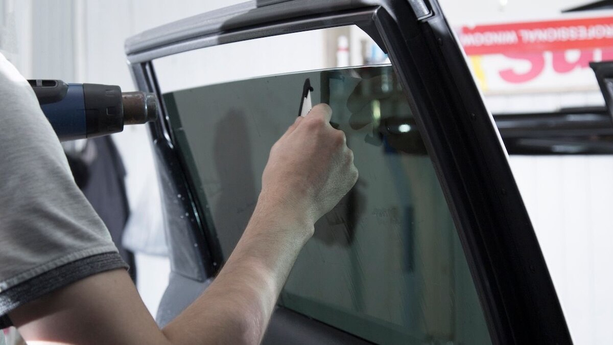 A technician installing car window tint.