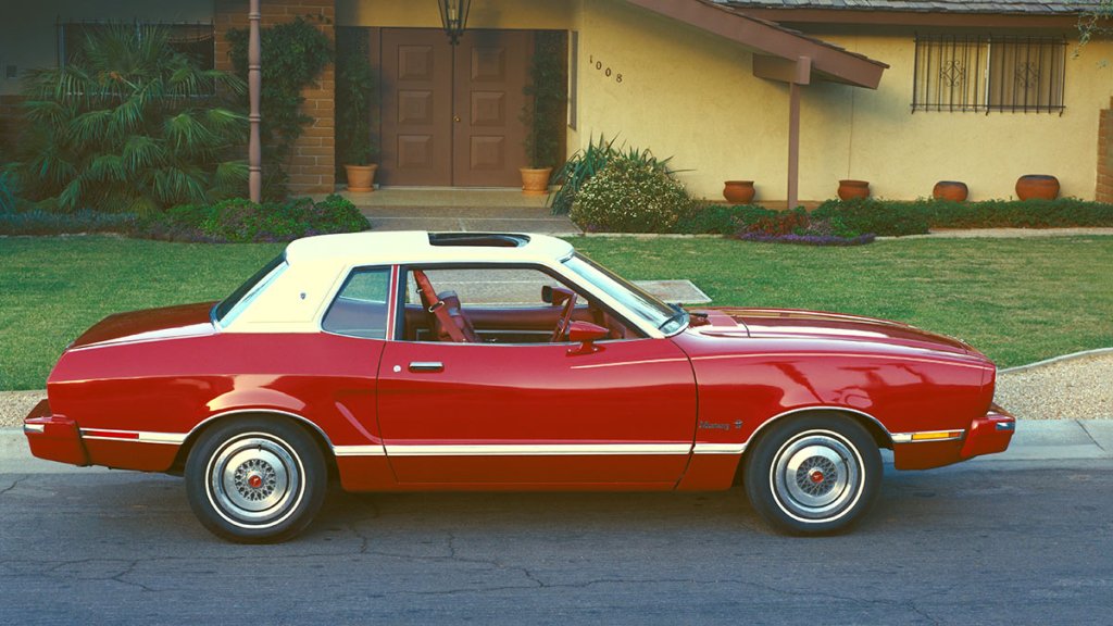 1974 Ford Mustang parked in front of a driveway.
